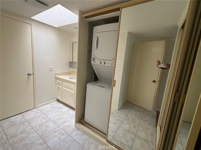 2268 Via Puerta Unit O, Laguna Woods, CA 92637 - washroom featuring estacked washer and dryer, light tile patterned floors, and a skylight