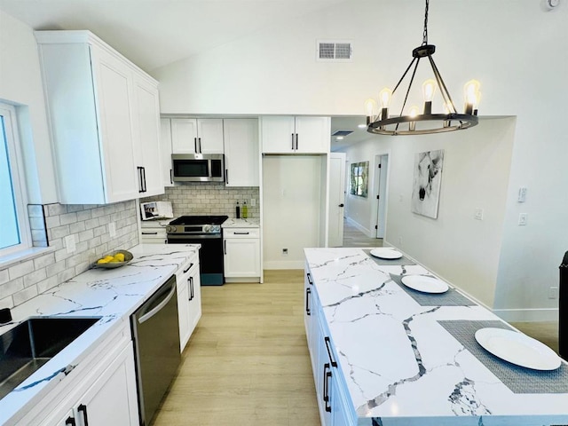 7118 Stanford Ave, La Mesa, CA 91942 - kitchen featuring stainless steel appliances, a chandelier, light stone counters, backsplash, and vaulted ceiling