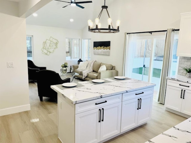 7118 Stanford Ave, La Mesa, CA 91942 - kitchen with light wood finished floors, healthy amount of natural light, white cabinets, a chandelier, and lofted ceiling