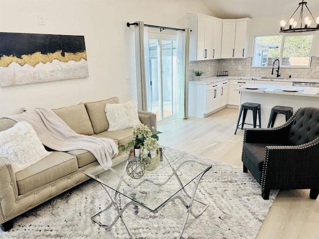 7118 Stanford Ave, La Mesa, CA 91942 - living room with light wood finished floors, a chandelier, and vaulted ceiling