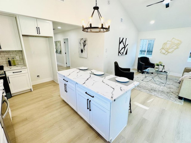 7118 Stanford Ave, La Mesa, CA 91942 - kitchen with open floor plan, light wood-style flooring, stove, a kitchen island, and light stone counters