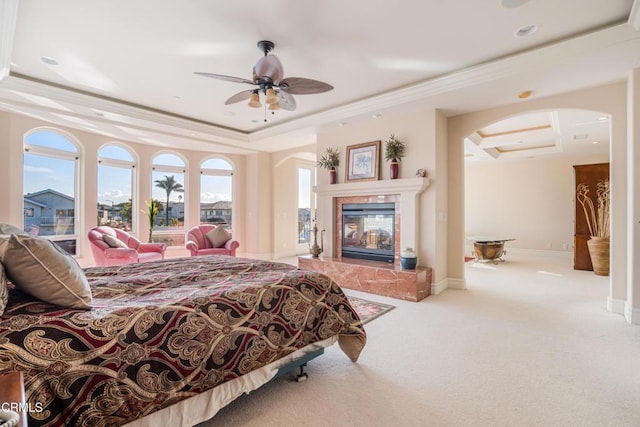2110 Ravoli Dr, Oxnard, CA 93035 - bedroom featuring a tray ceiling, a tile fireplace, ornamental molding, arched walkways, and carpet floors