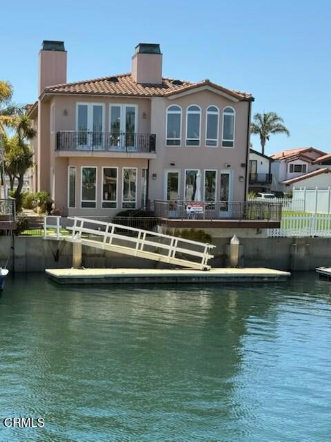 2110 Ravoli Dr, Oxnard, CA 93035 - back of property with a chimney, a balcony, a water view, and a tiled roof
