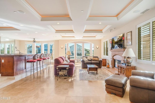 2110 Ravoli Dr, Oxnard, CA 93035 - living room with coffered ceiling, ornamental molding, a glass covered fireplace, ceiling fan, and beamed ceiling