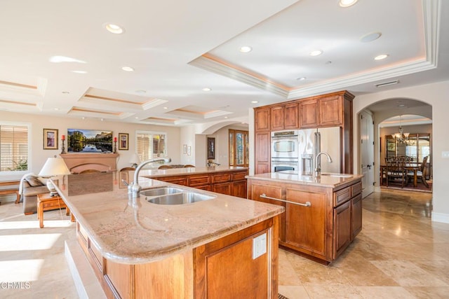 2110 Ravoli Dr, Oxnard, CA 93035 - kitchen with a large island with sink, arched walkways, plenty of natural light, crown molding, and coffered ceiling