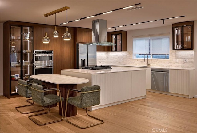 26144 Kenrose Cir, Calabasas, CA 91302 - kitchen featuring appliances with stainless steel finishes, island range hood, backsplash, light countertops, and a kitchen island
