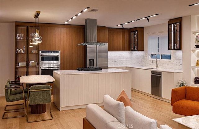 26144 Kenrose Cir, Calabasas, CA 91302 - kitchen featuring stainless steel appliances, wall chimney exhaust hood, light countertops, decorative backsplash, and a kitchen island