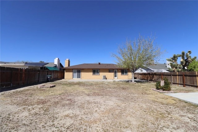 37334 55th St E, Palmdale, CA 93552 - rear view of property with a fenced backyard, stucco siding, and a chimney