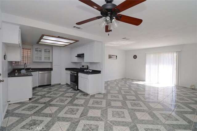 37334 55th St E, Palmdale, CA 93552 - kitchen with appliances with stainless steel finishes, dark countertops, white cabinets, glass insert cabinets, and ceiling fan