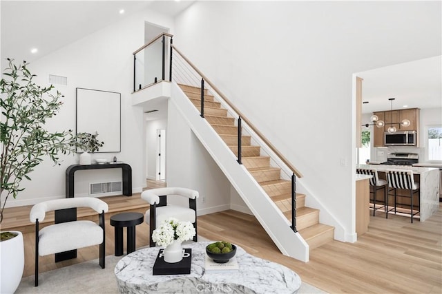 24091 Marathon St, Mission Viejo, CA 92691 - living room with a towering ceiling, stairs, light wood-style flooring, and recessed lighting