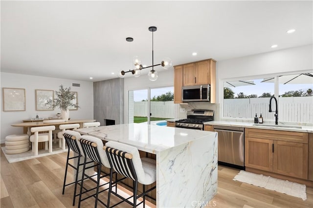 24091 Marathon St, Mission Viejo, CA 92691 - kitchen featuring stainless steel appliances, light wood-type flooring, recessed lighting, light stone countertops, and a breakfast bar area