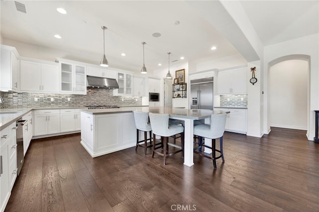 538 Francesca Ln, Glendora, CA 91741 - kitchen featuring built in appliances, under cabinet range hood, a kitchen island, backsplash, and arched walkways