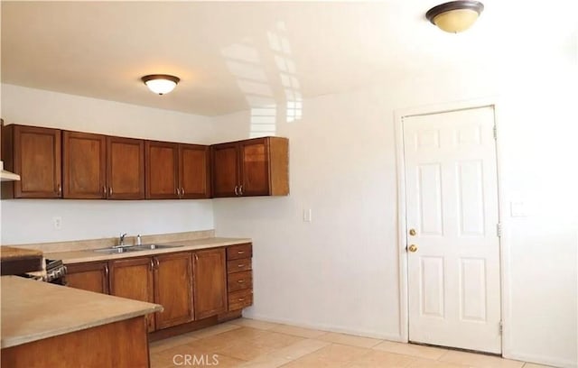 16226 Pine St, Hesperia, CA 92345 - kitchen featuring light countertops, brown cabinets, light tile patterned floors, and exhaust hood