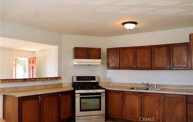 16226 Pine St, Hesperia, CA 92345 - kitchen featuring gas stove, under cabinet range hood, light countertops, and a peninsula