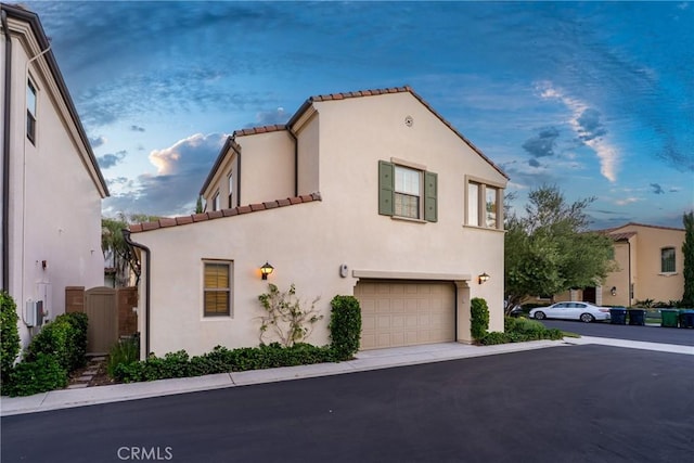 113 Soaring Eagle, Irvine, CA 92618 - view of front of house featuring a garage, a tiled roof, stucco siding, and driveway
