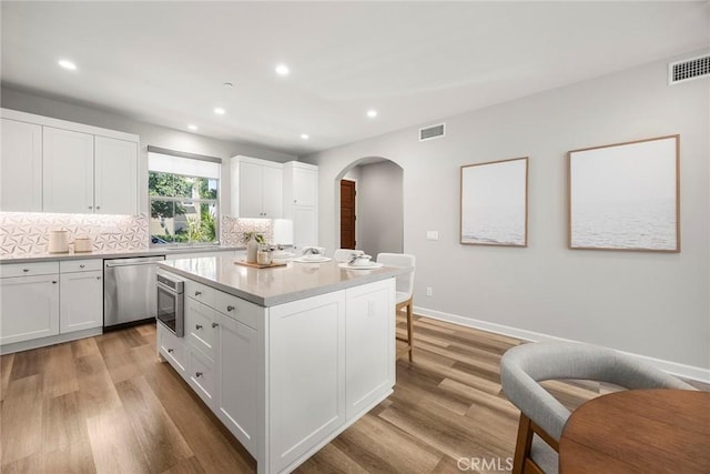 113 Soaring Eagle, Irvine, CA 92618 - kitchen featuring stainless steel appliances, arched walkways, light wood-style flooring, recessed lighting, and tasteful backsplash