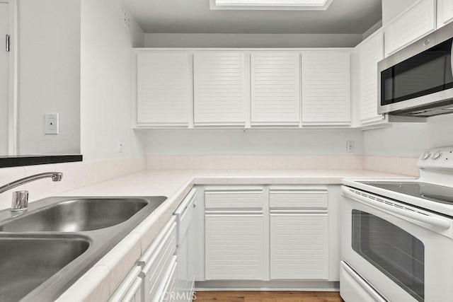 13104 Glen Ct Unit 7, Chino Hills, CA 91709 - kitchen with electric stove, stainless steel microwave, white cabinets, and light countertops