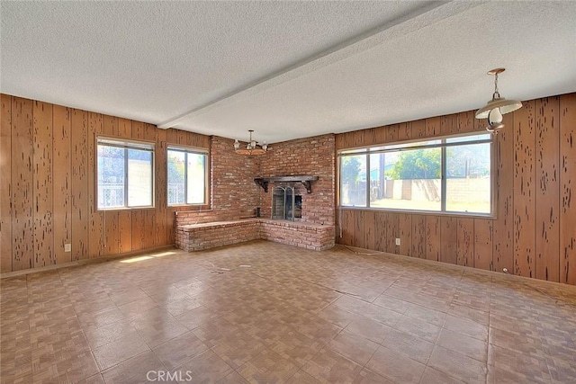 833 W Orangepath St, Glendora, CA 91741 - unfurnished living room with wood walls, healthy amount of natural light, a fireplace, and a textured ceiling