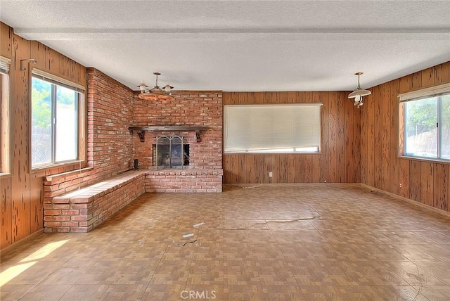 833 W Orangepath St, Glendora, CA 91741 - unfurnished living room with wooden walls, a chandelier, a textured ceiling, and a brick fireplace
