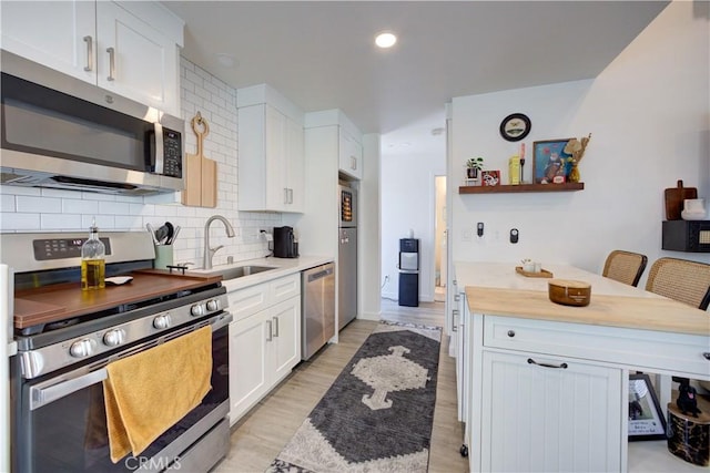 5926 Gran Paseo Way, Atascadero, CA 93422 - kitchen with appliances with stainless steel finishes, white cabinetry, tasteful backsplash, open shelves, and light wood-style flooring