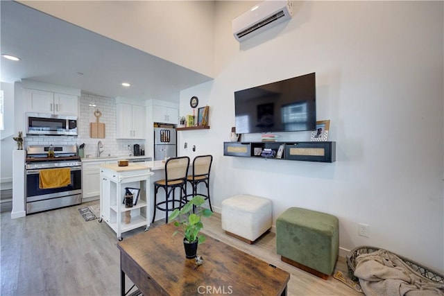 5926 Gran Paseo Way, Atascadero, CA 93422 - living area featuring an AC wall unit, light wood-style floors, and recessed lighting