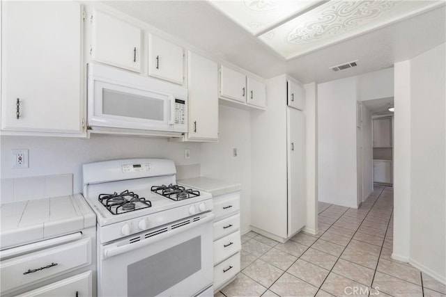41384 Collegian Way, Hemet, CA 92544 - kitchen with white appliances, tile counters, white cabinetry, and light tile patterned floors