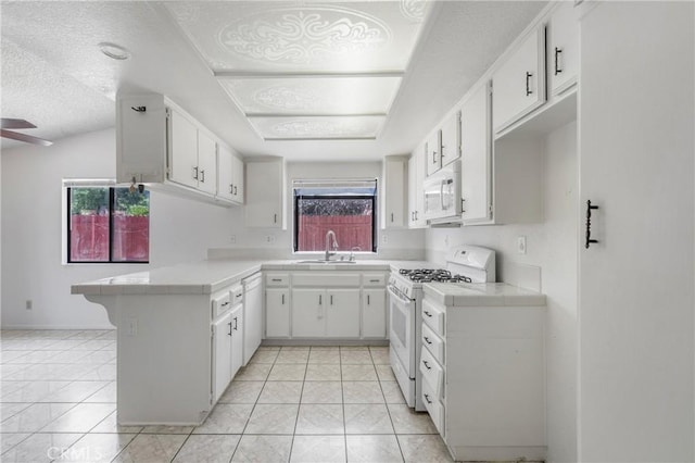 41384 Collegian Way, Hemet, CA 92544 - kitchen featuring white appliances, a peninsula, tile countertops, white cabinetry, and a textured ceiling