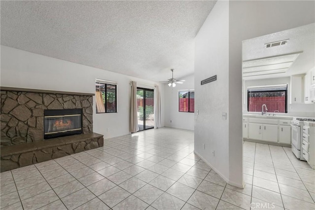 41384 Collegian Way, Hemet, CA 92544 - unfurnished living room with light tile patterned flooring, a textured ceiling, a fireplace, a ceiling fan, and lofted ceiling