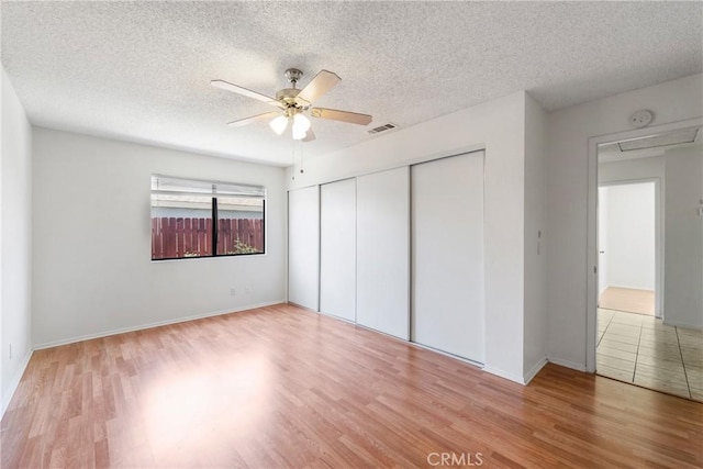 41384 Collegian Way, Hemet, CA 92544 - unfurnished bedroom with wood finished floors, a closet, a textured ceiling, and a ceiling fan