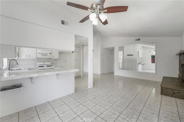41384 Collegian Way, Hemet, CA 92544 - kitchen with white appliances, tile countertops, vaulted ceiling, ceiling fan, and a peninsula