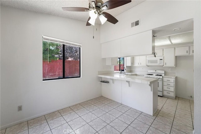 41384 Collegian Way, Hemet, CA 92544 - kitchen featuring white appliances, a peninsula, white cabinetry, a textured ceiling, and a ceiling fan