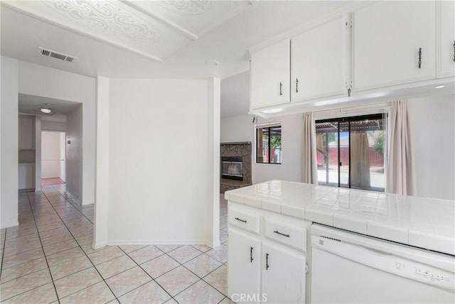 41384 Collegian Way, Hemet, CA 92544 - kitchen with white dishwasher, tile countertops, light tile patterned floors, a fireplace, and white cabinets