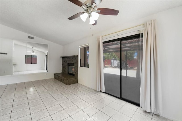 41384 Collegian Way, Hemet, CA 92544 - unfurnished living room with a ceiling fan, lofted ceiling, a fireplace, light tile patterned floors, and a textured ceiling