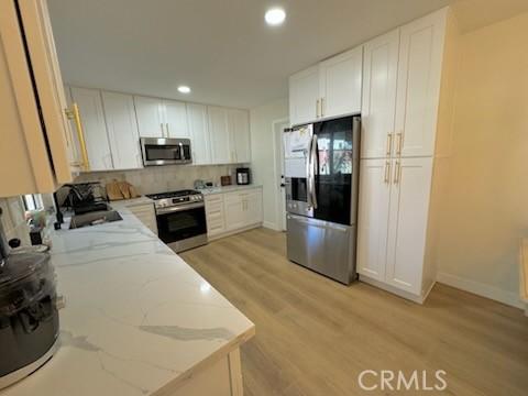 1308 Dixon Ct, Chula Vista, CA 91911 - kitchen featuring stainless steel appliances, light wood finished floors, recessed lighting, tasteful backsplash, and light stone countertops