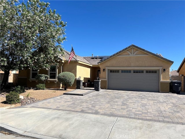 3345 James Ct, Lancaster, CA 93535 - single story home with stucco siding, solar panels, an attached garage, and driveway