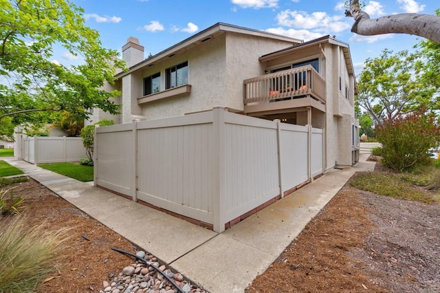 2005 Countrywood Ct, Encinitas, CA 92024 - rear view of house featuring a chimney, stucco siding, and a balcony