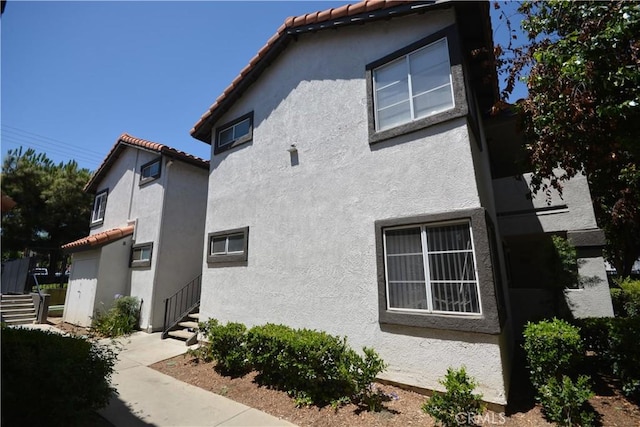 16377 Lakeshore Dr Unit 4D, Lake Elsinore, CA 92530 - view of side of property featuring stucco siding and a tiled roof