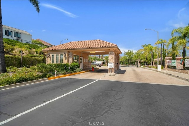 19900 Mariposa Creek Way, Porter Ranch, CA 91326 - view of asphalt road featuring street lights, curbs, and a gated entry