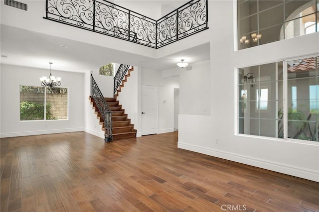 19900 Mariposa Creek Way, Porter Ranch, CA 91326 - unfurnished living room with a chandelier, stairway, wood finished floors, and a towering ceiling