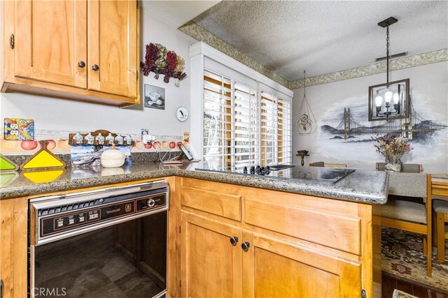 1595 15th St, Los Osos, CA 93402 - kitchen with black appliances, a textured ceiling, pendant lighting, and stone counters