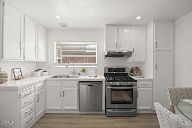 5217 Hillridge Dr, Camarillo, CA 93012 - kitchen with stainless steel appliances, under cabinet range hood, white cabinets, backsplash, and recessed lighting