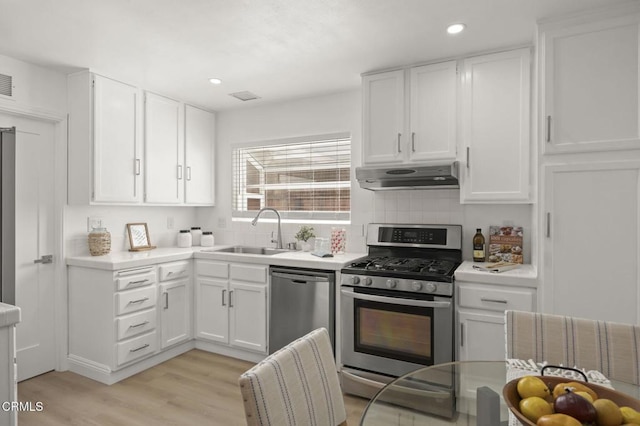 5217 Hillridge Dr, Camarillo, CA 93012 - kitchen featuring appliances with stainless steel finishes, under cabinet range hood, white cabinets, light wood-style flooring, and recessed lighting