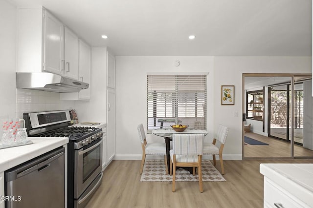 5217 Hillridge Dr, Camarillo, CA 93012 - kitchen with appliances with stainless steel finishes, under cabinet range hood, light wood finished floors, white cabinetry, and plenty of natural light