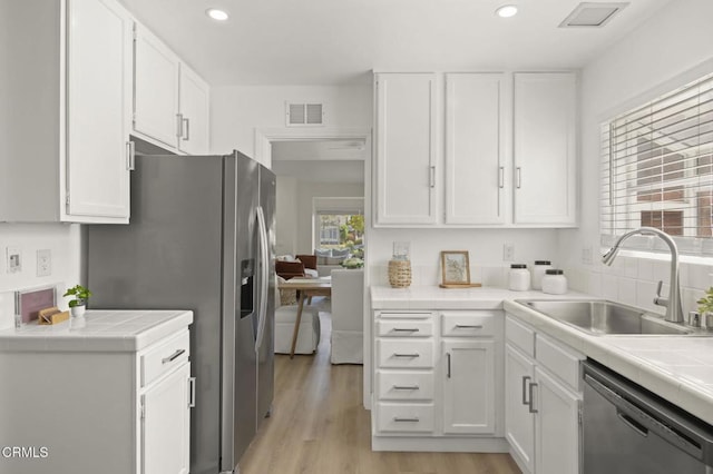 5217 Hillridge Dr, Camarillo, CA 93012 - kitchen featuring stainless steel appliances, tile countertops, white cabinets, light wood-style floors, and recessed lighting