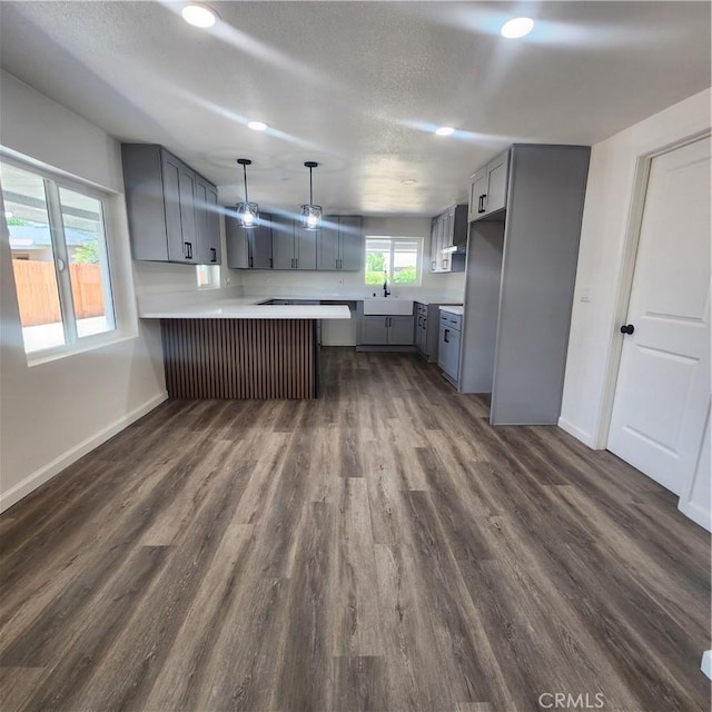 3087 N Lugo Ave, San Bernardino, CA 92404 - kitchen with gray cabinets, a peninsula, light countertops, dark wood-style floors, and recessed lighting