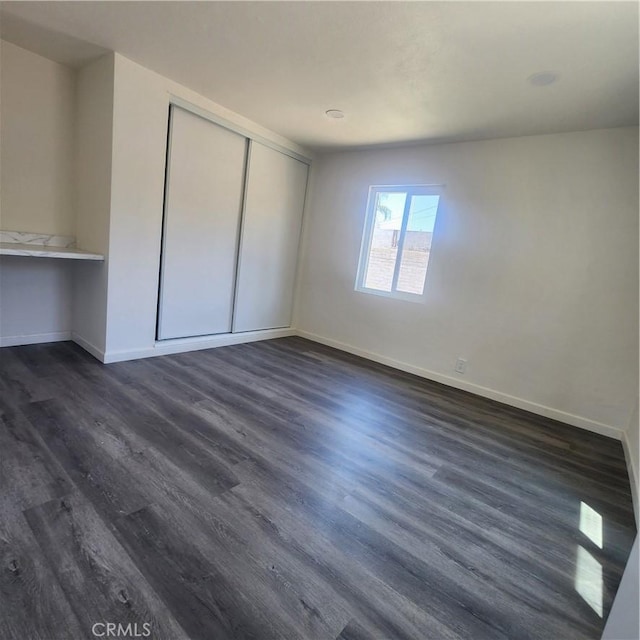 3087 N Lugo Ave, San Bernardino, CA 92404 - unfurnished bedroom with dark wood-style flooring and a closet