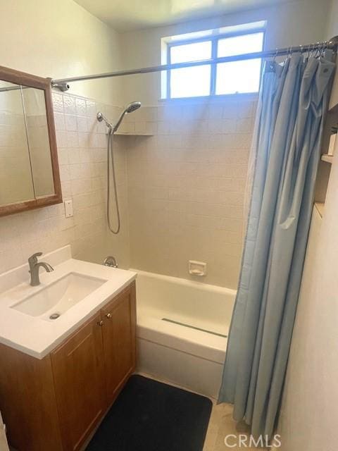 15343 Leahy Ave, Bellflower, CA 90706 - bathroom featuring shower / bath combo with shower curtain, vanity, healthy amount of natural light, backsplash, and tile walls