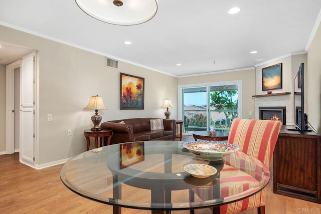 1560 Circa Del Lago Unit D204, San Marcos, CA 92078 - dining room featuring light wood finished floors, a glass covered fireplace, recessed lighting, and crown molding