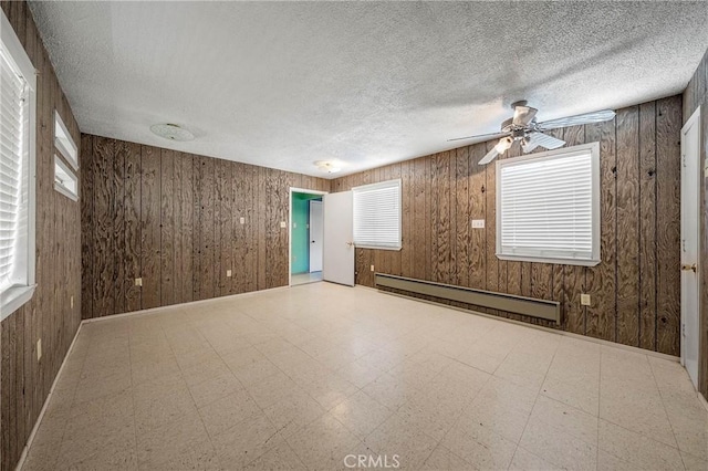 16374 35th Ave Unit 2, Clearlake, CA 95422 - spare room featuring a baseboard radiator, ceiling fan, wooden walls, a textured ceiling, and tile patterned floors