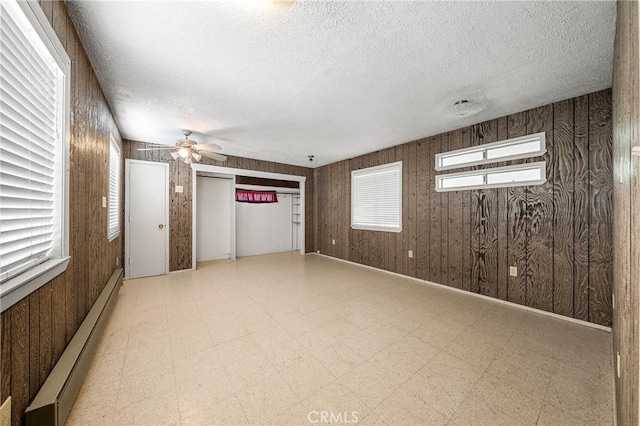 16374 35th Ave Unit 2, Clearlake, CA 95422 - spare room with a baseboard radiator, a ceiling fan, a textured ceiling, tile patterned floors, and healthy amount of natural light